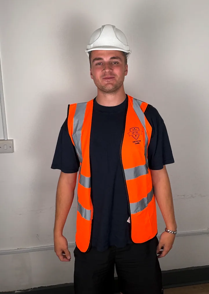 Young student in a white helmet and Lift Tec hi vis vest before his assessment