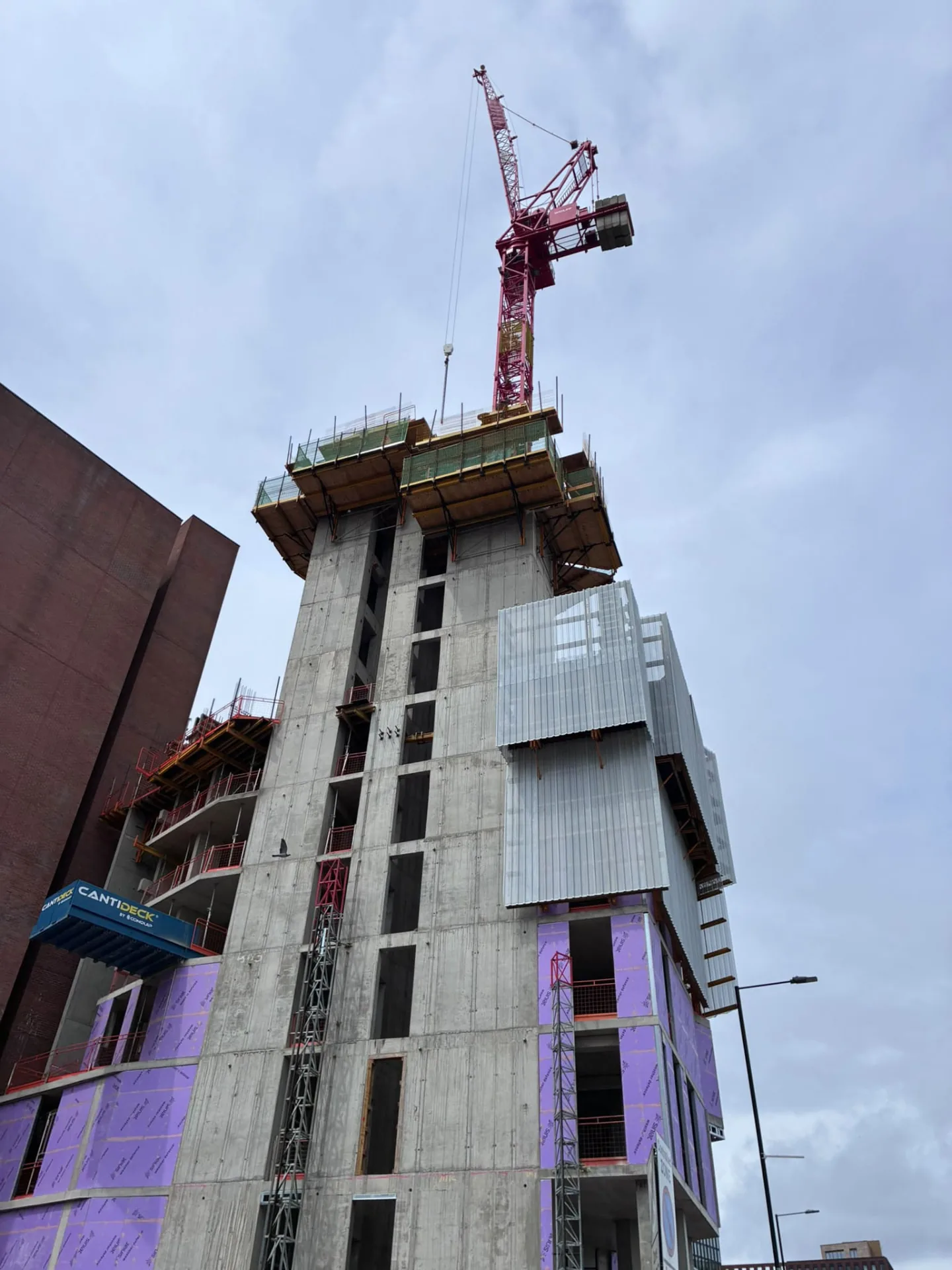 Tower crane above a high rise concrete frame under construction